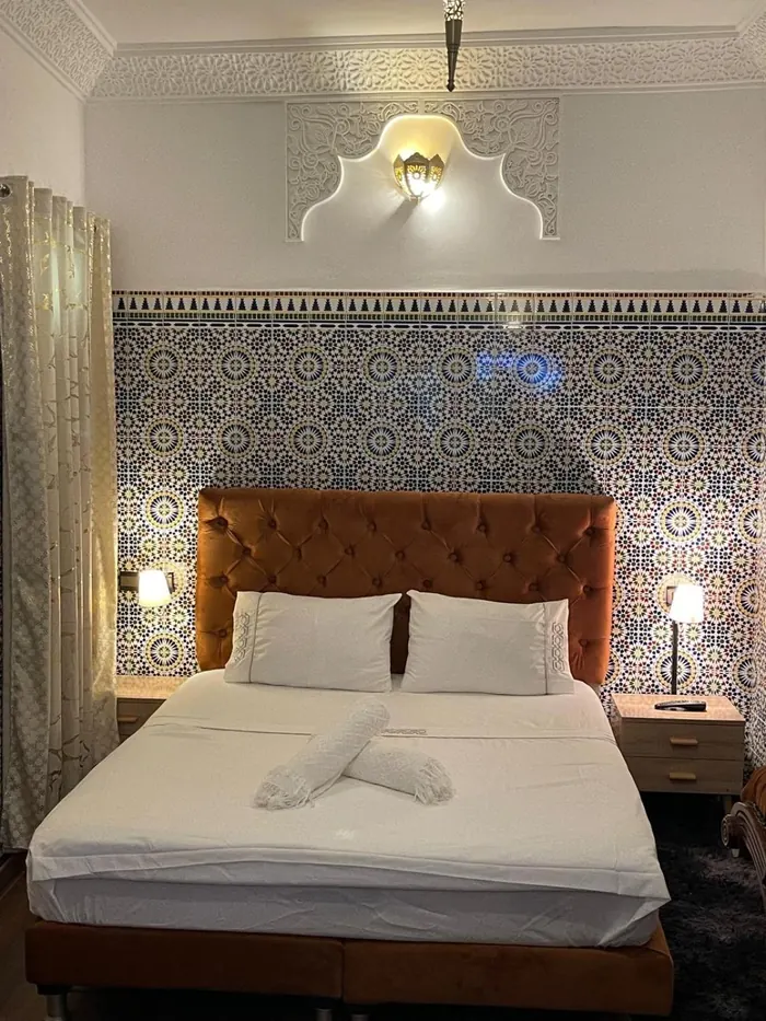 Le grand lit de la chambre Deluxe, tête de lit capitonnée