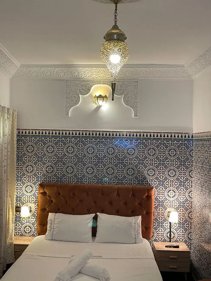 La chambre Deluxe, mur en zellige bleu et lanterne